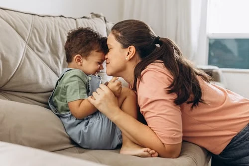 Madre junto a su hijo en el sofá; fotografía ilustrativa, no testimonio de pacientes